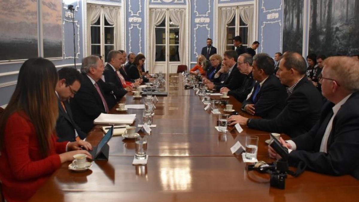 Gathering of people at a long table discussing Foreign Affairs